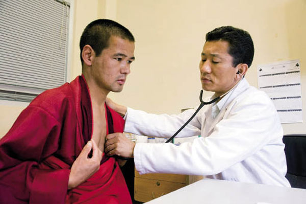 Een arts onderzoekt een monnik.
