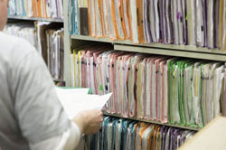 Ziekenhuismedewerkers verwerken gegevens in medische dossiers. In bepaalde gevallen mag de inspectie de dossiers inzien. beeld: Corbis 