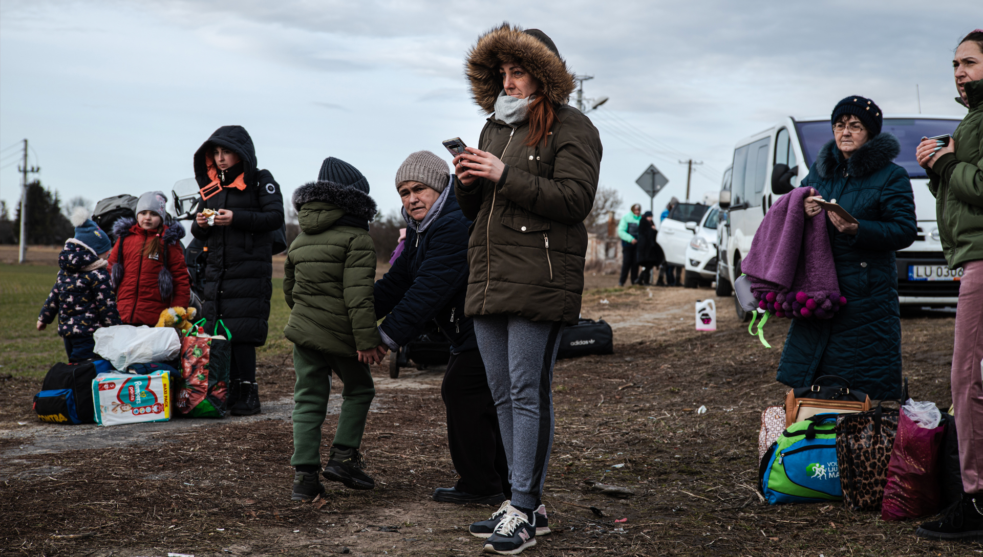 ANP?Hollandse Hoogte/Martin Bruining - Oekraïnse vluchtelingen wachten aan de Poolse kant van de grens op vervoer naar een opvangplek elders in Europa.