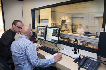 Docent Ruben Verlangen (links) en Rob Lichtveld sturen de simulaties aan vanuit de regiekamer. De actie wordt met vier camera’s opgenomen.
