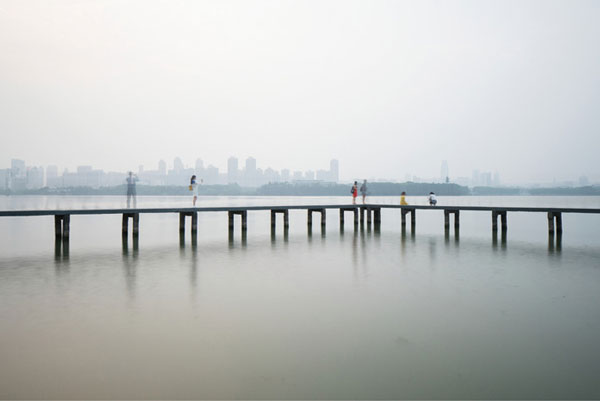 Flaneren aan het water in een mist van smog. Door luchtvervuiling sterven per jaar 1,6 miljoen mensen in China, ofwel 4400 per dag.   © Ruben Terlou