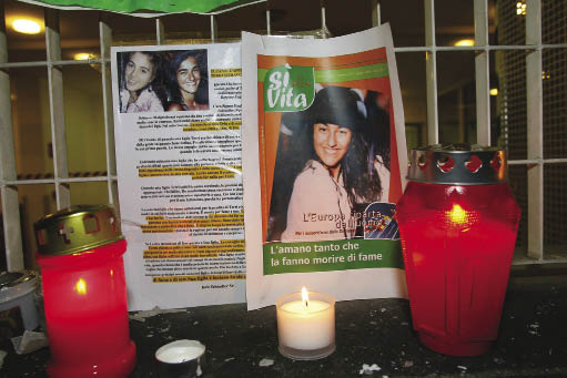Kaarsen bij het portret van Eluana Englaro, die, door eindeloos juridisch getouwtrek, vijftien jaar lang in vegetatieve toestand leefde voordat ze mocht sterven. Beeld: ANP Photo
