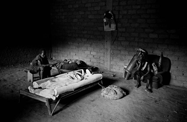 Nabestaanden rouwen bij het bed van een overleden vrouw in Kameroen. <BR>Beeld: Marcus Bleasdale/VII, HH